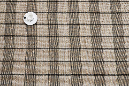 Alfombra de fibra marina con patrón a cuadros y borde ribeteado